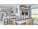 Bright dining area with a kitchen view, modern lighting fixture, and seating for six, perfect for Gathering meals at 12469 Gust Ct, Hudson, FL 34669