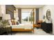 A well-lit bedroom featuring a four-poster bed, bedside tables, modern lamps, and seating at 12597 Lily Quartz Loop, Parrish, FL 34219
