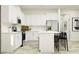 A well-lit kitchen featuring white cabinets, stainless steel appliances, and a convenient center island with chairs at 12597 Lily Quartz Loop, Parrish, FL 34219