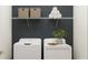 Modern laundry room with new front load machines, storage shelves, neutral paint and accent plant at 12597 Lily Quartz Loop, Parrish, FL 34219