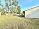 Image of large grass yard with view of house and trees against blue skies at 13100 Serpentine Dr, Hudson, FL 34667