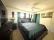 Cozy bedroom with a ceiling fan, decorative accents, and large windows for ample light at 13100 Serpentine Dr, Hudson, FL 34667
