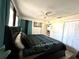 Bedroom with a decorative bedspread, ceiling fan, closet, and an open doorway to an adjoining room at 13100 Serpentine Dr, Hudson, FL 34667
