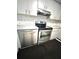 Close-up of the stainless steel oven and dishwasher, complemented by a modern tile backsplash at 13100 Serpentine Dr, Hudson, FL 34667