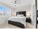 Cozy bedroom featuring a dark wooden bed frame, neutral linens, plantation shutters and a ceiling fan at 1321 Custer Bayou St, Ruskin, FL 33570