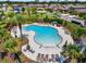 Aerial shot of the community pool, featuring ample lounge seating, palm trees, and a -safe shallow area at 1321 Custer Bayou St, Ruskin, FL 33570