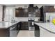 Close-up view of kitchen showcasing stainless steel appliances, dark cabinetry and granite countertops at 1321 Custer Bayou St, Ruskin, FL 33570