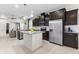 Open-concept kitchen showcasing stainless steel appliances, dark cabinetry, granite countertops, and a central island at 1321 Custer Bayou St, Ruskin, FL 33570
