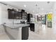 Spacious kitchen featuring dark cabinets, granite countertops, stainless steel appliances, and a center island at 1321 Custer Bayou St, Ruskin, FL 33570