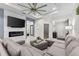 Bright living room with a large sectional, modern fireplace and an oversized ceiling fan at 1321 Custer Bayou St, Ruskin, FL 33570