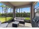 Screened patio with wicker furniture and a view of the backyard with palm trees at 1321 Custer Bayou St, Ruskin, FL 33570