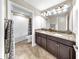 Bathroom featuring granite countertops, dual sinks, modern lighting, and tiled floor at 13903 Sage Thrasher Ln, Riverview, FL 33579