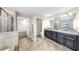 Bright bathroom features double sinks, large mirror, tile flooring, glass enclosed shower, and toilet at 13903 Sage Thrasher Ln, Riverview, FL 33579