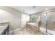 Bright bathroom features double sinks, large mirror, tile flooring, glass enclosed shower, and large bathtub at 13903 Sage Thrasher Ln, Riverview, FL 33579