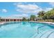 Beautiful community pool with accessible entry and nearby pool house in a well-maintained tropical setting at 13903 Sage Thrasher Ln, Riverview, FL 33579