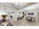 Open-concept dining area with tile floors, a modern light fixture, and neutral decor at 13903 Sage Thrasher Ln, Riverview, FL 33579
