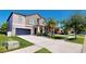 Charming two-story home featuring a dark garage door, landscaped yard, and inviting front porch at 13903 Sage Thrasher Ln, Riverview, FL 33579