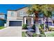 Charming two-story home featuring a dark garage door, landscaped yard, and inviting front porch at 13903 Sage Thrasher Ln, Riverview, FL 33579