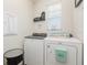 Functional laundry room featuring a modern washer and dryer set with convenient shelving at 13958 Richland Gulf Cir, Parrish, FL 34219