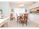 Well-lit dining room with a wood table set for six, a chandelier and open to the living spaces at 14840 Shipwatch Trce # 1924, Largo, FL 33774