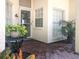 Inviting front porch with brick flooring, potted plants, and a charming entrance door at 14840 Shipwatch Trce # 1924, Largo, FL 33774