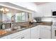Bright kitchen featuring white cabinetry, granite countertops, and modern stainless steel appliances at 14840 Shipwatch Trce # 1924, Largo, FL 33774