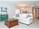 Bright living room with white sofa, decorative pillows, and wood coffee table in an open layout at 14840 Shipwatch Trce # 1924, Largo, FL 33774