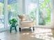 Bright sunroom with chair, plant and large windows overlooking the lush greenery outside at 14840 Shipwatch Trce # 1924, Largo, FL 33774