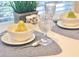 Elegant table setting with crystal glasses, pear, and ceramic bowls for fine dining at 14840 Shipwatch Trce # 1924, Largo, FL 33774