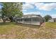 This backyard features a screened in patio, green grass and a clear blue sky at 1521 Fireside St, Port Charlotte, FL 33952
