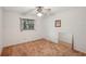 This bedroom features a window, a ceiling fan, and neutral walls with carpeted flooring at 1521 Fireside St, Port Charlotte, FL 33952
