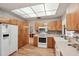 Well-lit kitchen featuring wood cabinets, white appliances, a mosaic backsplash, and hardwood flooring at 1521 Fireside St, Port Charlotte, FL 33952