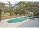 This pool features a screened in enclosure, patio and a clear blue sky at 1521 Fireside St, Port Charlotte, FL 33952