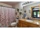 Bathroom with wooden vanity, granite countertop, and floral shower curtain at 15625 Olney Ln, Spring Hill, FL 34610