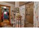 Shower with tiled walls next to a toilet and a doorway to the laundry room at 15625 Olney Ln, Spring Hill, FL 34610