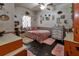 Cozy bedroom features a plush pink bed, wooden floors, and charming decor, perfect for relaxation at 15625 Olney Ln, Spring Hill, FL 34610