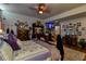 Bedroom featuring hardwood floors, a ceiling fan, TV, dresser and mirrored closet doors at 15625 Olney Ln, Spring Hill, FL 34610