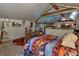 Cozy bedroom featuring sloped ceilings with wooden beams and unique decor at 15625 Olney Ln, Spring Hill, FL 34610