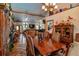 Spacious dining area that connects to the living room and has an antique wooden table with cushioned chairs at 15625 Olney Ln, Spring Hill, FL 34610