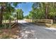 Gated driveway surrounded by lush trees, providing privacy and a welcoming entrance to the property at 15625 Olney Ln, Spring Hill, FL 34610