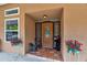 Close-up of the front door entrance with decorative glass, rocking chairs, and flower decor at 15625 Olney Ln, Spring Hill, FL 34610