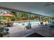 Spacious covered patio with outdoor dining and lounge areas overlooking the sparkling swimming pool at 15625 Olney Ln, Spring Hill, FL 34610