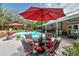 Refreshing pool area with comfortable seating, vibrant umbrellas, and lush landscaping for a resort-like feel at 15625 Olney Ln, Spring Hill, FL 34610