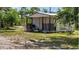Charming shed with a cozy porch, nestled among trees and greenery, on a sunny day at 15625 Olney Ln, Spring Hill, FL 34610