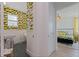 Stylish bathroom featuring lemon wallpaper, a sink, and a view to the bedroom at 1579 Bayshore Blvd, Dunedin, FL 34698