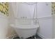 Clawfoot tub with white curtains, decorative hardware, and unique tiling at 1579 Bayshore Blvd, Dunedin, FL 34698