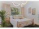 Bright main bedroom featuring a gold bed frame, neutral accents, and large window letting in natural light at 1579 Bayshore Blvd, Dunedin, FL 34698