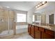 Bathroom features a glass shower, bath tub, and double vanity with granite countertop at 16016 Persimmon Grove Dr, Lithia, FL 33547