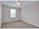 Bedroom features carpet flooring, a ceiling fan, and a large window at 16016 Persimmon Grove Dr, Lithia, FL 33547