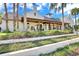Community clubhouse featuring a covered porch, well-kept landscaping and palm trees at 16016 Persimmon Grove Dr, Lithia, FL 33547